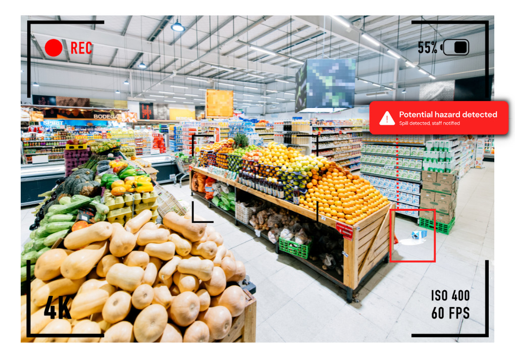 Image of a supermarket viewed through a camera lens, in the scene is a carton of milk which has spilled on to the floor with a box around it leading to a notification reading